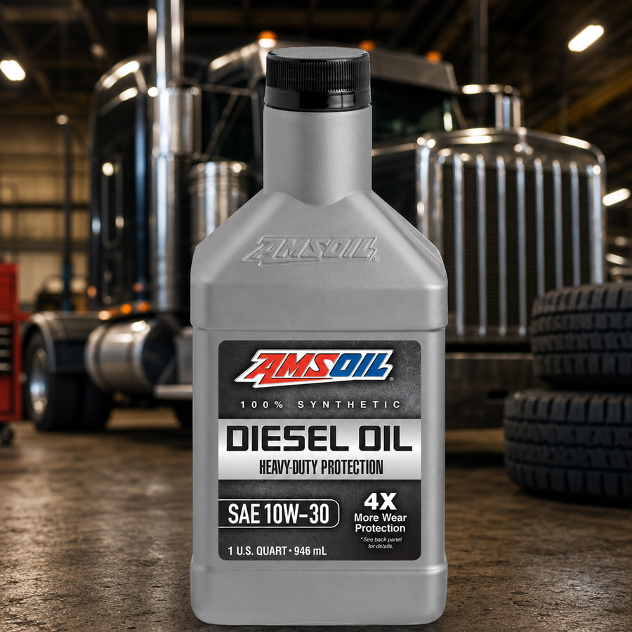 AMSOIL 10W-30 Heavy-Duty 100% Synthetic Diesel Oil staged in a diesel truck shop