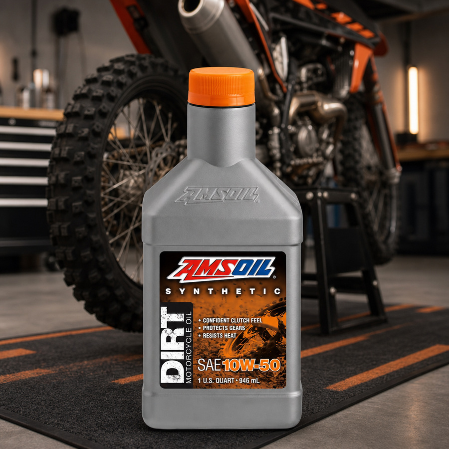 AMSOIL 10W-50 100% Synthetic Dirt Bike Oil staged in a motocross pit area