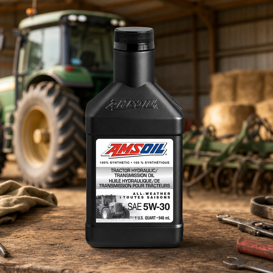 AMSOIL 5W-30 100% Synthetic Tractor Hydraulic/Transmission Oil staged in a farm equipment shop