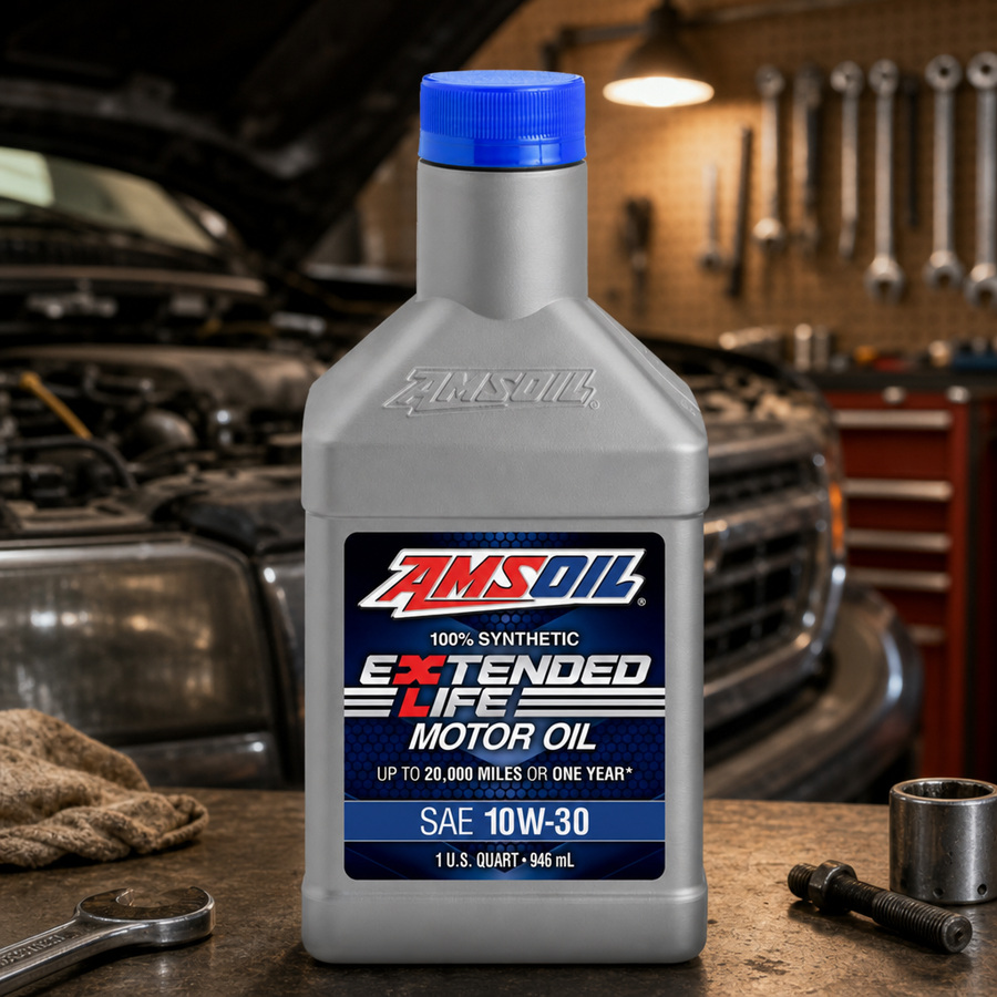 AMSOIL Extended-Life 10W-30 100% Synthetic Motor Oil staged in an automotive service garage