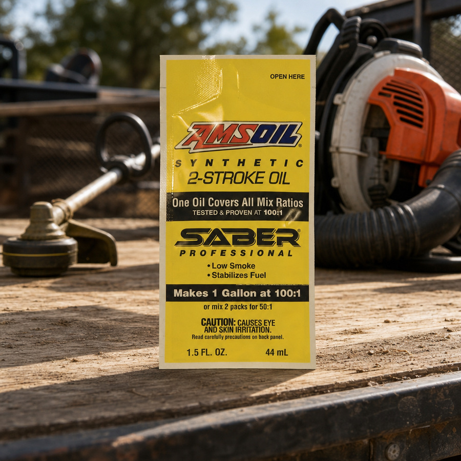 AMSOIL SABER Professional 100% Synthetic 2-Stroke Oil staged in an outdoor power equipment shop