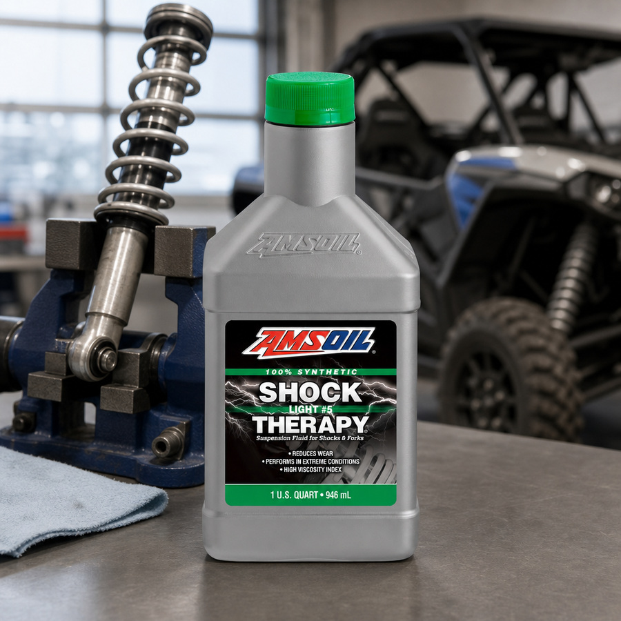 AMSOIL Shock Therapy #5 Light Suspension Fluid staged in an automotive workshop